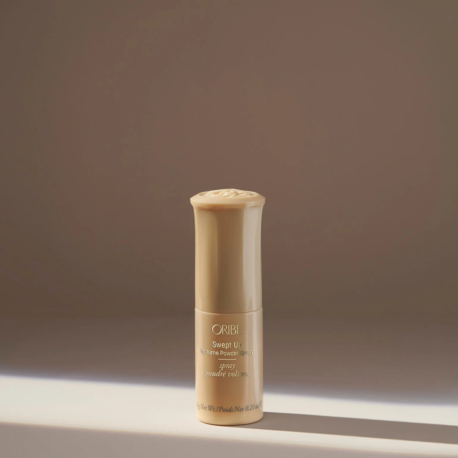 Oribe hair product bottle on a neutral background