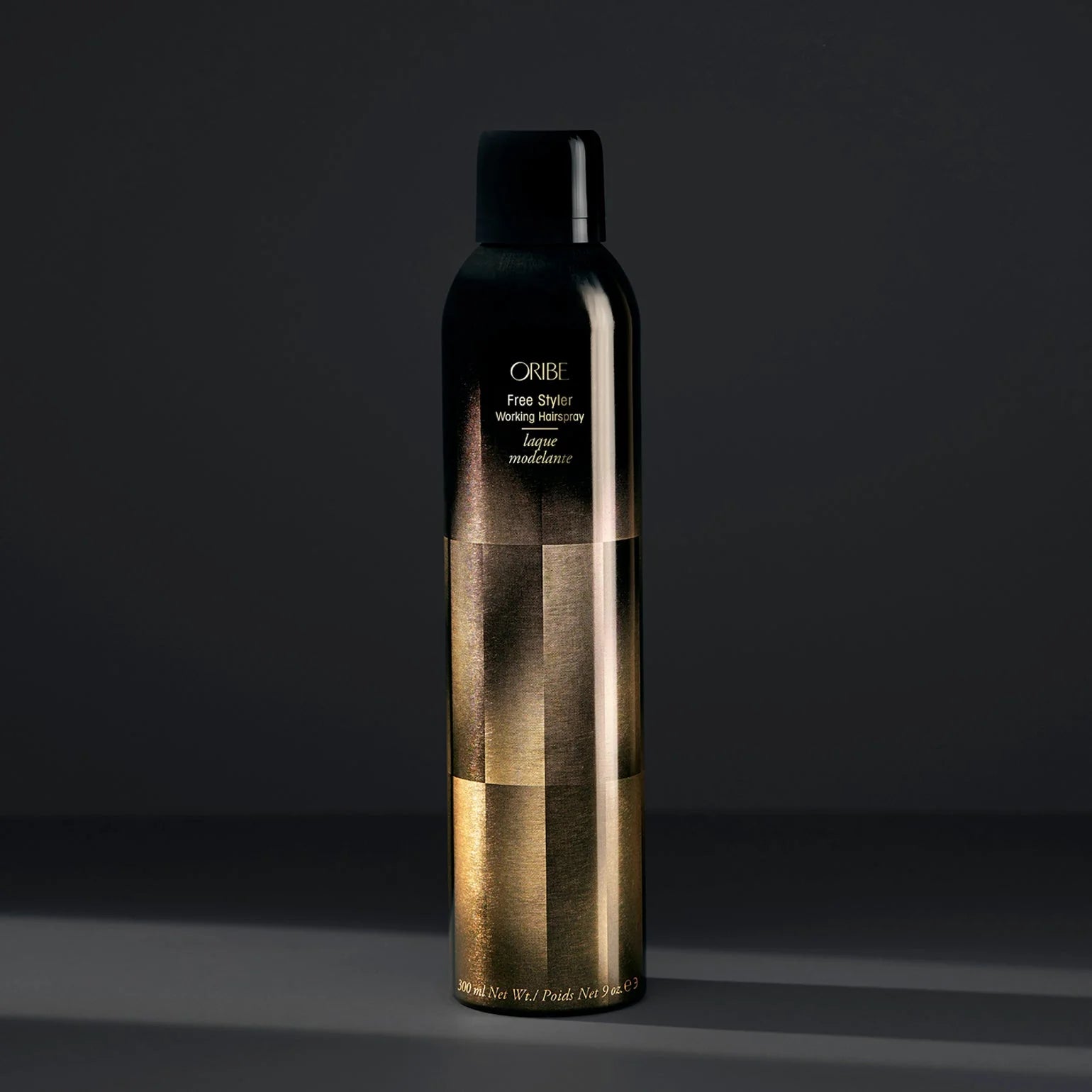 Oribe hair spray bottle on a dark background