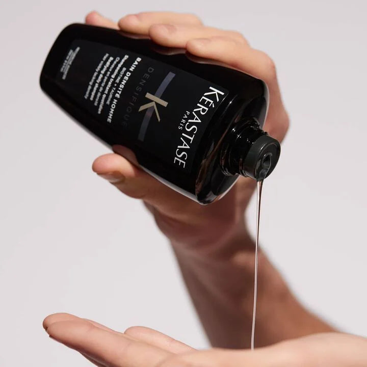 Person pouring Kerastase product into their hand against a neutral background