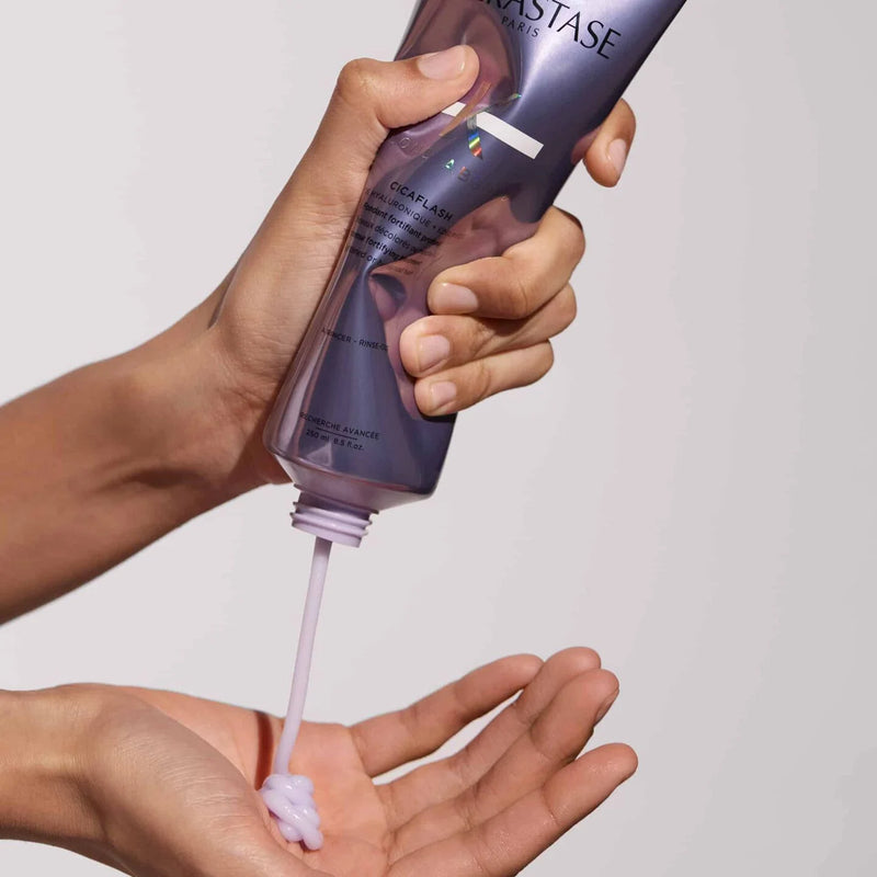 Kerastase Cicaflash Conditioner bottle being sqeezed and poured onto open palm hand
