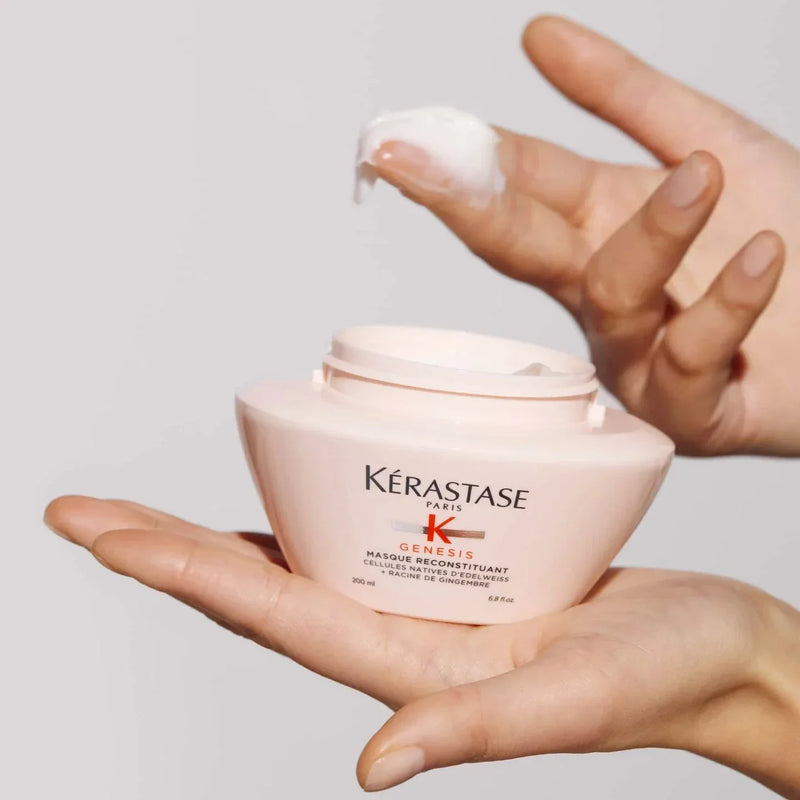 Kérastase hair mask jar held by a hand with a small amount of product on the指尖