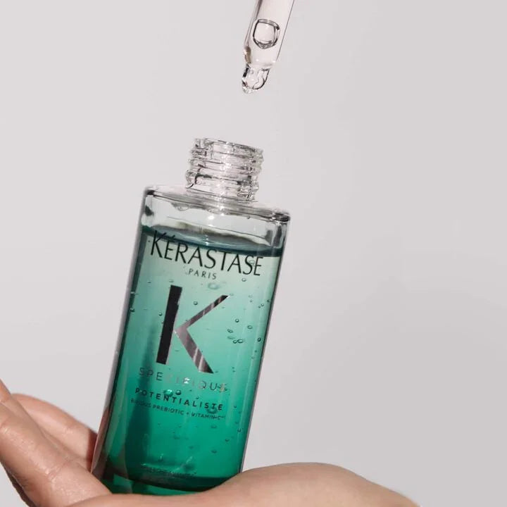 Kerastase bottle with dropper on a plain background