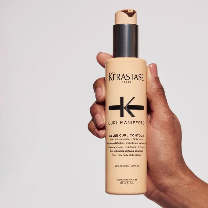 Kérastase Curl Manifesto product held in a hand against a plain background