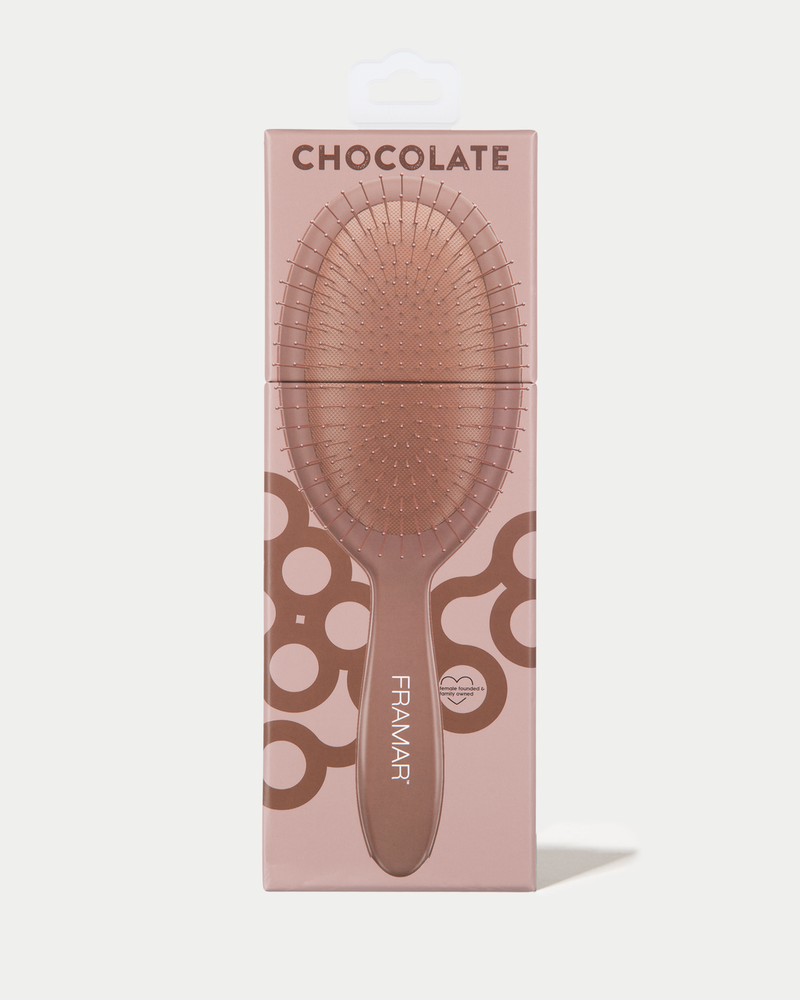 Hairbrush with packaging labeled 'Chocolate' by Framar on a light pink background