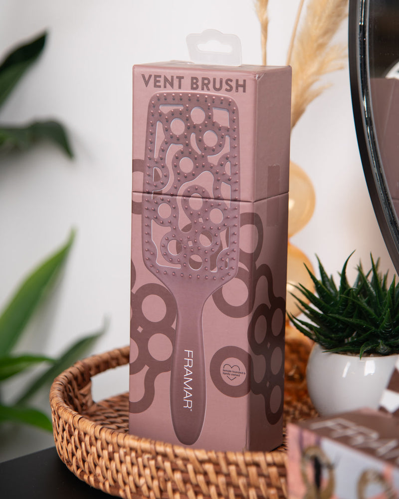 Pink vent brush packaging with decorative patterns on a blurred background
