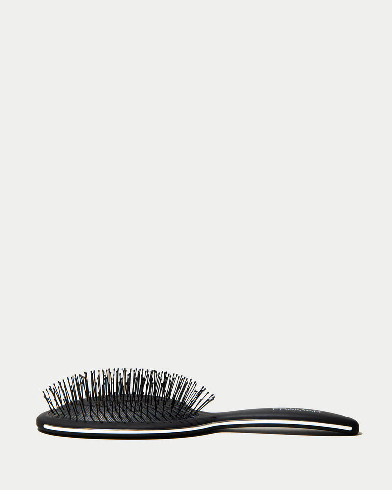 Black hairbrush on a white background