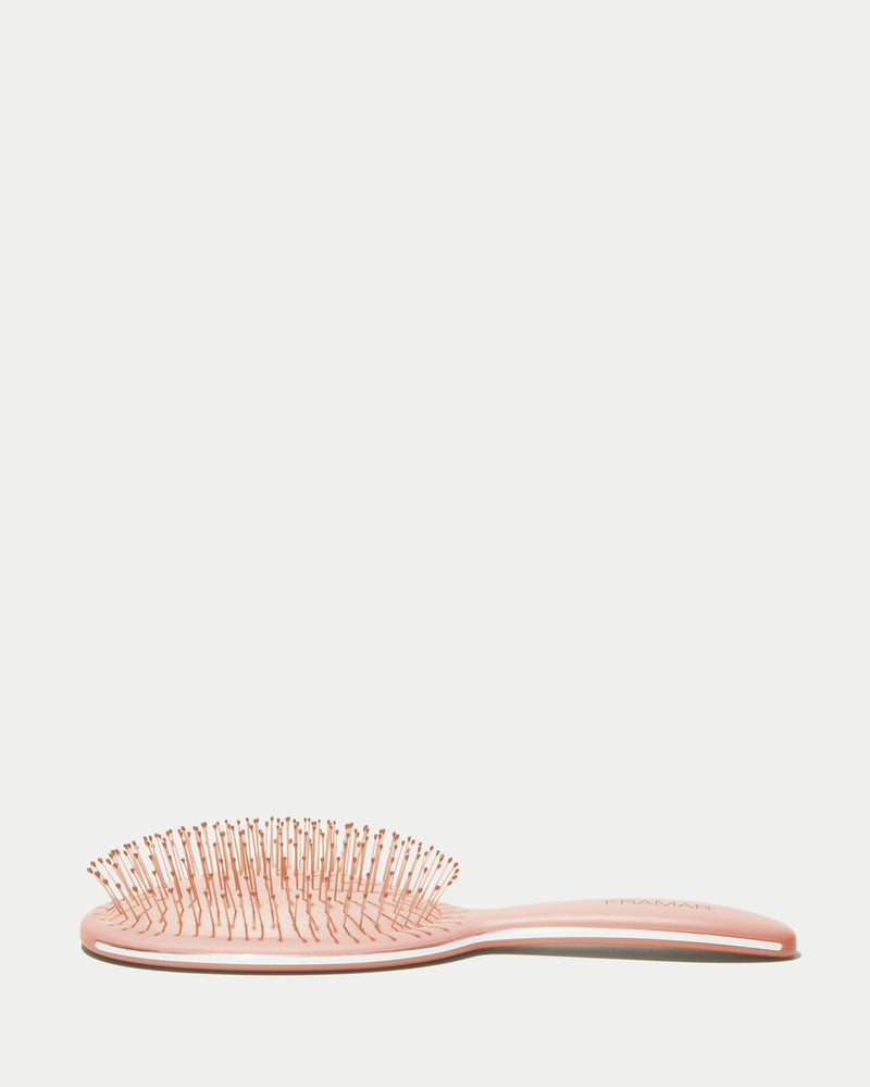 Pink hairbrush on a light gray background