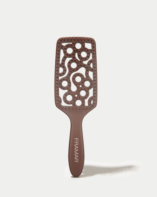Brown hairbrush with decorative pattern on a white background
