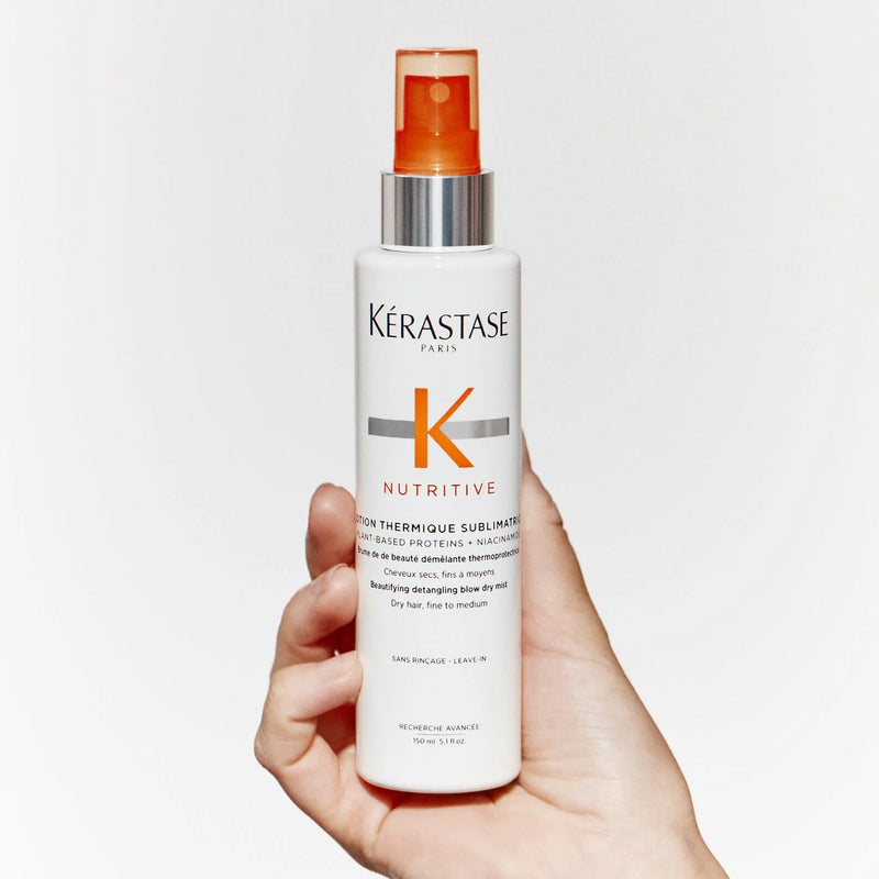 Kérastase Nutritive hair care product held in a hand against a white background