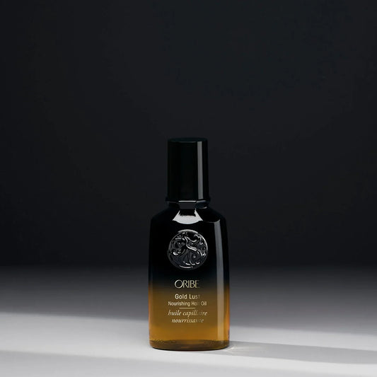 Oribe Gold Lust nourishing hair oil bottle on a dark background