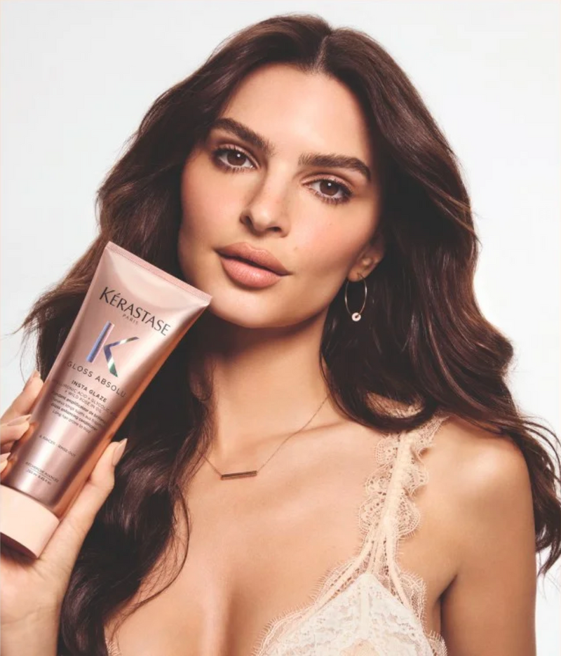 Woman holding a Kerastase product against a plain background
