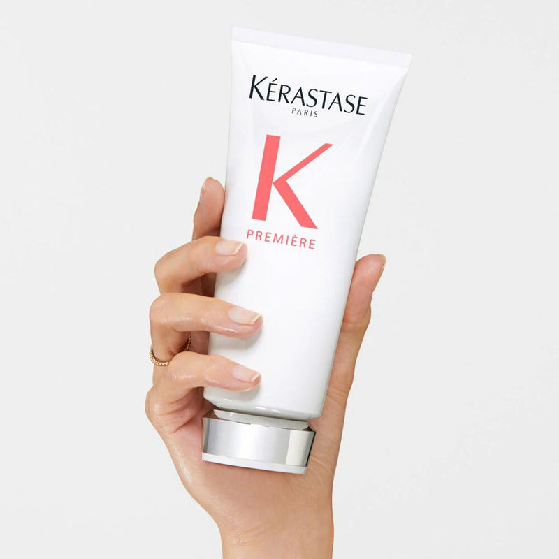 Hand holding a Kérastase product against a white background