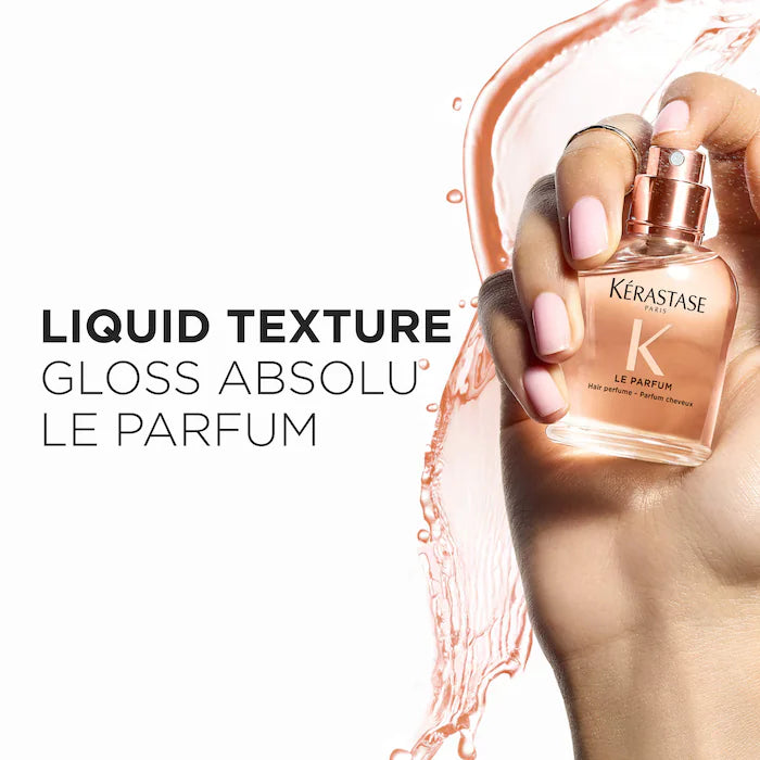 Kérastase Gloss Absolu Le Parfum bottle held by a hand with pink nail polish on a white background.