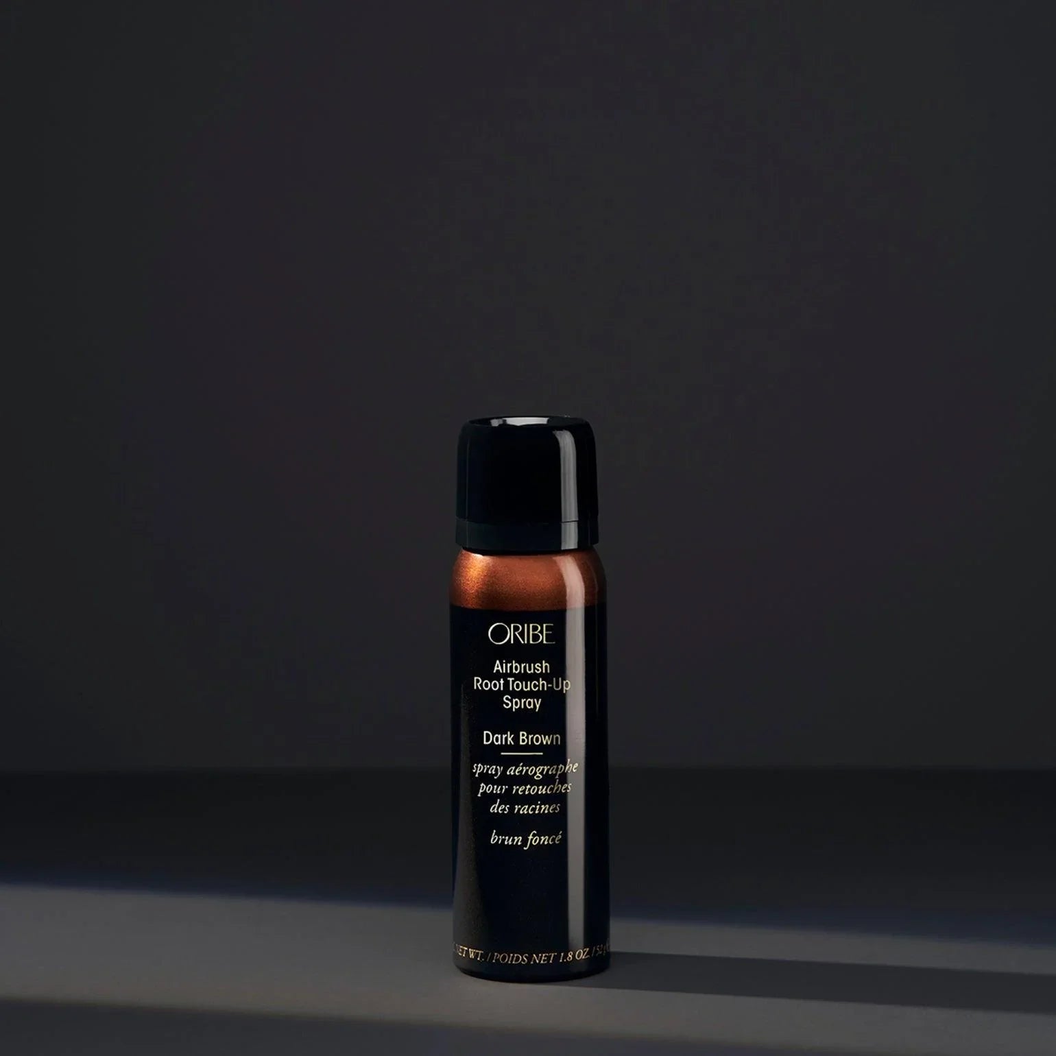 A spray bottle of Oribe Airbrush Root Touch-Up Spray in Dark Brown, designed for covering greys and roots or refreshing highlights.