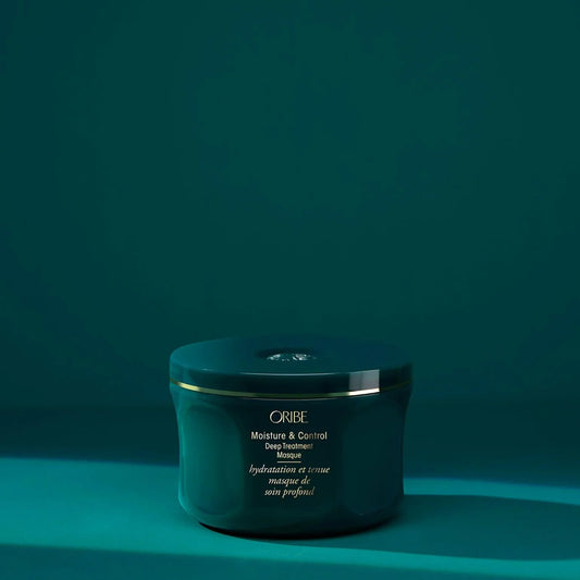 A green tub of ORIBE Moisture & Control Deep Treatment Masque against a green background