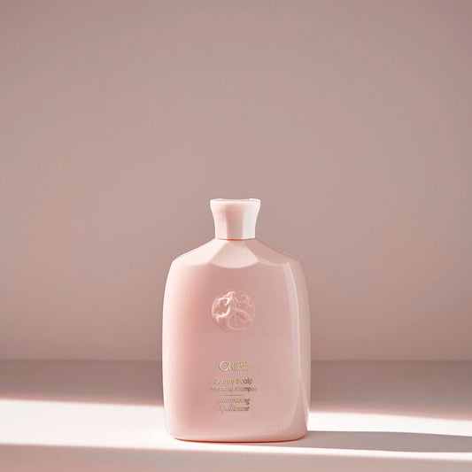 A pink bottle of ORIBE Serene Scalp Balancing Shampoo against a plain background.