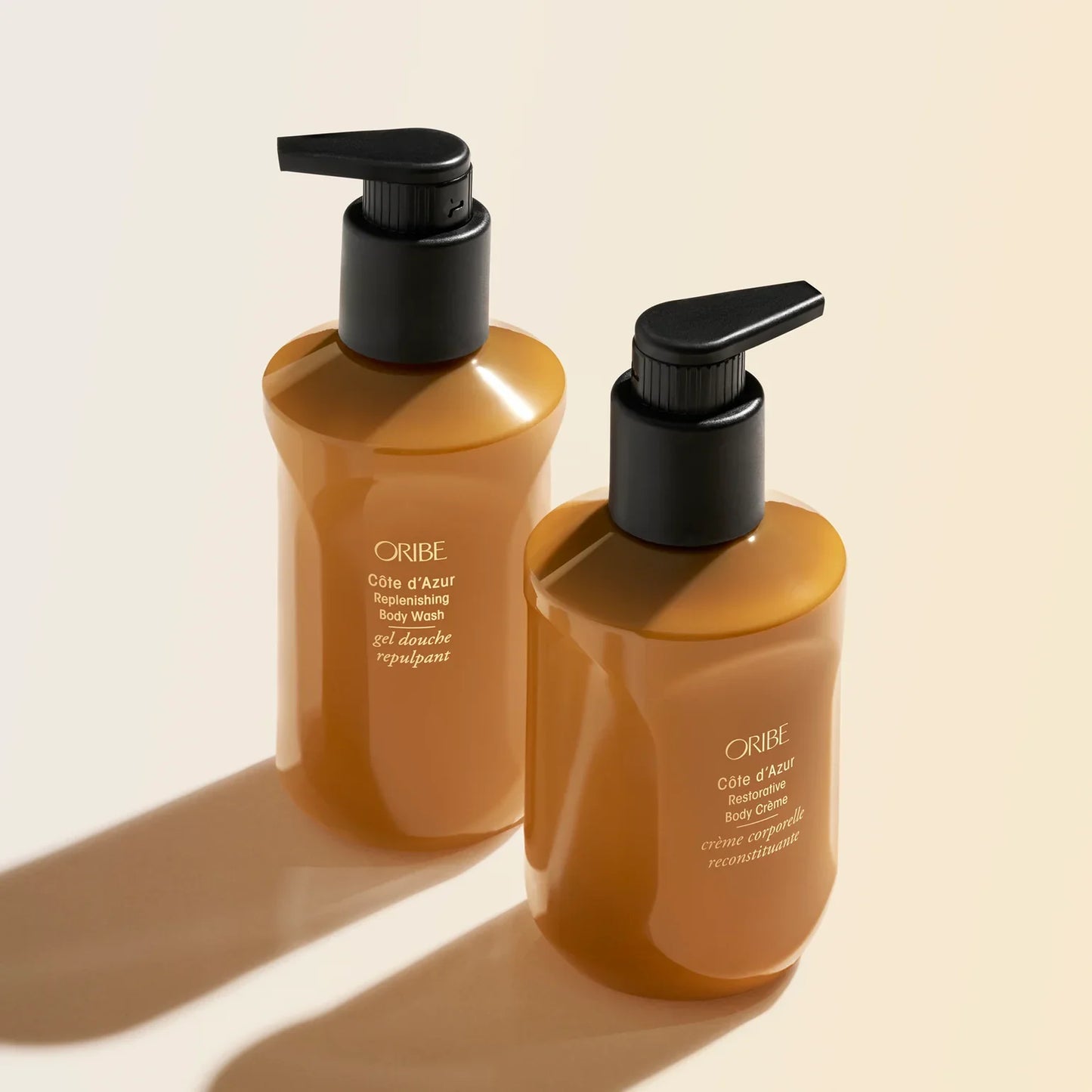 Two Oribe bottles on a beige background