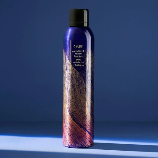 Bottle of ORIBE Apres Beach Wave and Shine Spray on blue background