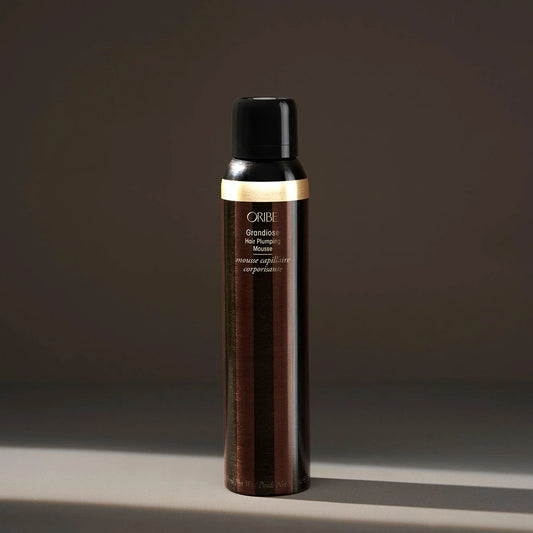 A spray bottle of ORIBE Grandiose Hair Plumping Mousse.
