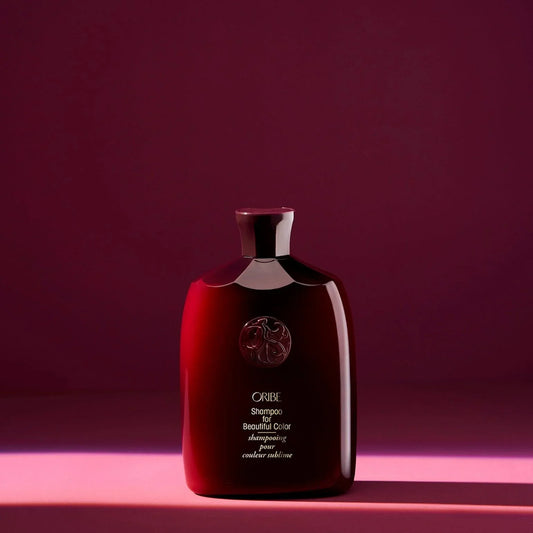Red bottle of ORIBE Shampoo for Beautiful Color with red background