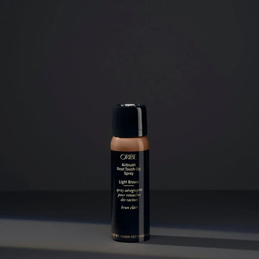 A spray bottle of Oribe Airbrush Root Touch-Up Spray in Light Brown, designed for covering greys and roots or revive highlights.